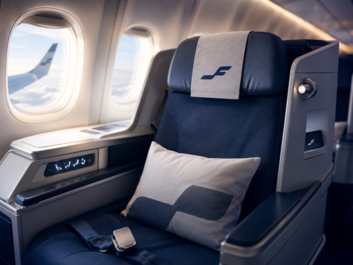 Finnair Business Class seat inside a modern aircraft cabin with a window view during flight.